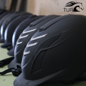 Kuvassa on rivissä ratsastuskypäriä